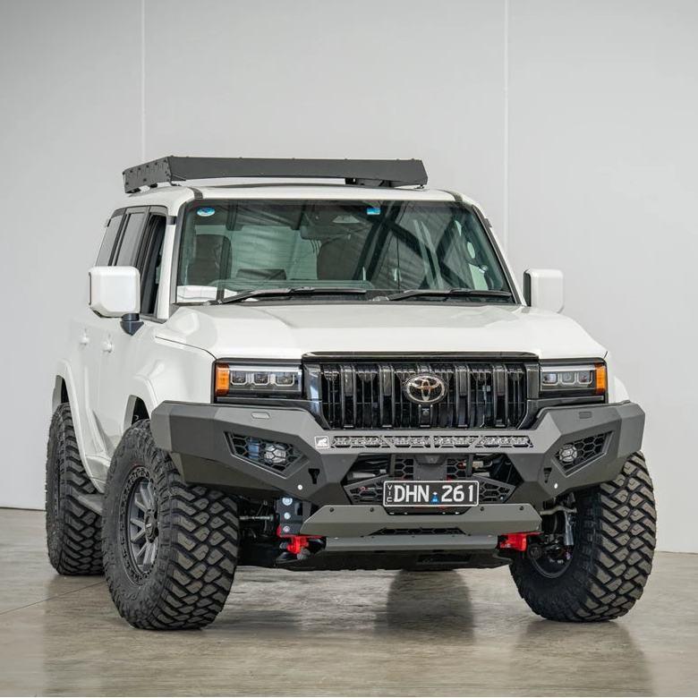 White Toyota truck with off-road modifications in a studio setting