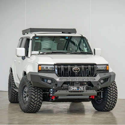 White Toyota truck with off-road modifications in a studio setting